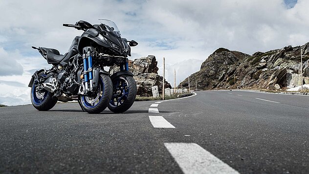 Sportmotorrad auf einer kurvigen Hochalpenstraße nahe Ischgl, felsige Berglandschaft im Hintergrund.